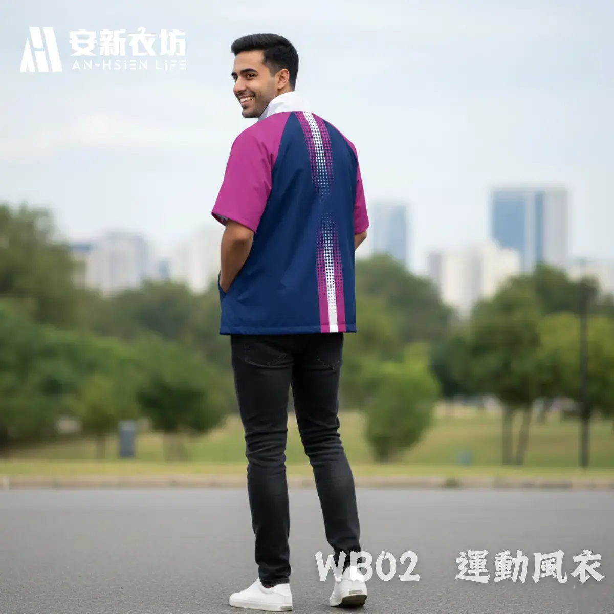 安新衣坊WB02運動風衣男版專業實穿照背面視角。男模特兒站立於都會公園，展示深藍與紫紅拼接短袖防風外套。背部中央帶有科技感點陣漸層直條紋設計，視覺俐落修身，適合城市路跑與企業休閒穿搭。