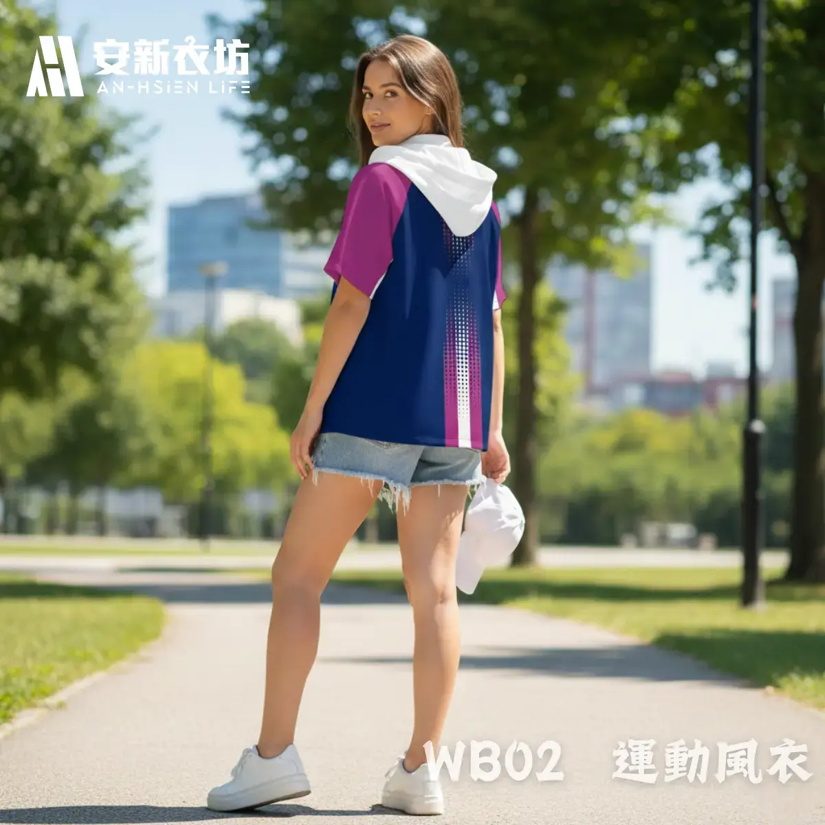 安新衣坊WB02運動風衣女版專業實穿照背面視角。女模特兒於都會公園回眸，展示深藍與紫紅拼接短袖防風外套內搭白色連帽上衣，並搭配休閒丹寧短褲。背部科技感點陣漸層直條紋完美呈現都會運動休閒風格。
