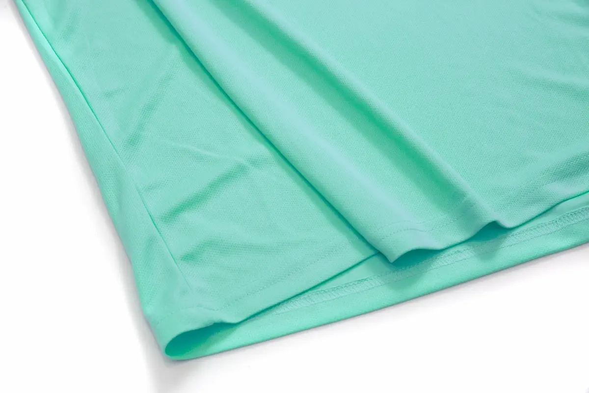 安新衣坊 CP101 海藍色排汗休閒圓領素T恤下擺特寫。展示 CP Sports 高機能排汗布料的透氣織紋與細緻平整的雙線包邊車工，展現服飾的高耐穿度與質感。