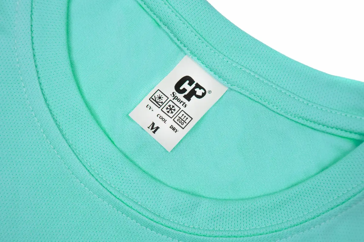 安新衣坊CP101排汗休閒圓領素T恤領口特寫照。展示海藍色透氣鳥眼布料的細緻紋理與平整雙車線領口，並突顯印有UV+抗紫外線、COOL涼感、DRY快乾三大機能圖示的CP Sports原廠標籤。