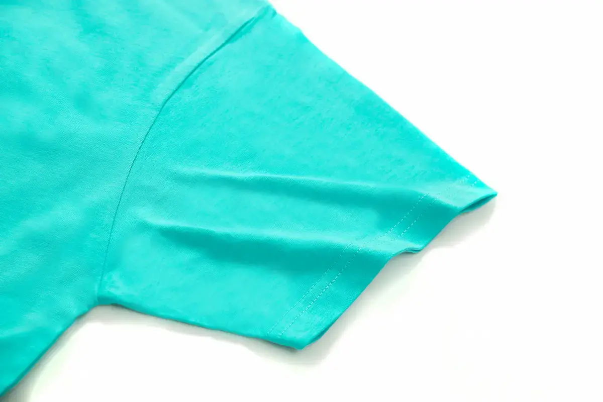 ARRIVE GUIDE AG21000 重磅 T 恤下擺近照，展示均勻細緻的雙針加強縫線與厚實的面料邊緣，確保洗滌後下擺不捲曲變形。