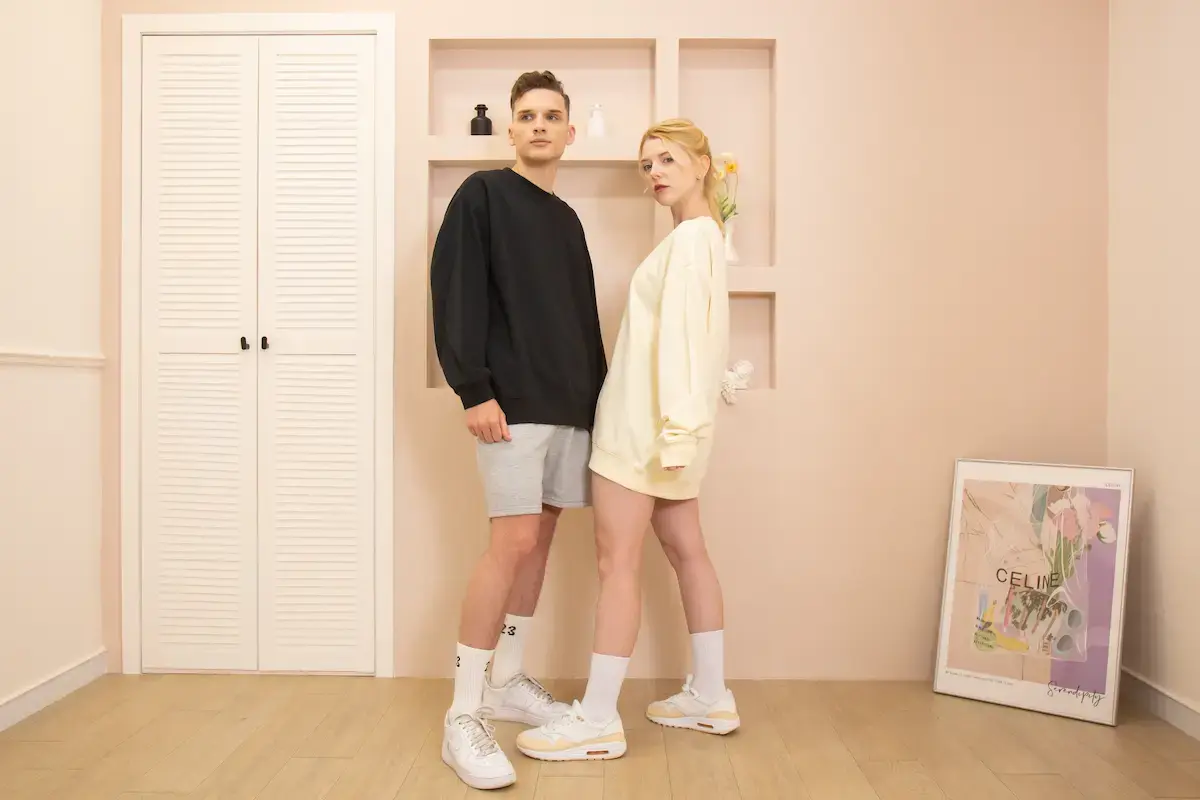 Arrive Guide AG1000 重磅寬版落肩大學T實穿圖，男模穿著黑色搭配灰色短褲，女模穿著奶油色展現長版 Oversize 風格