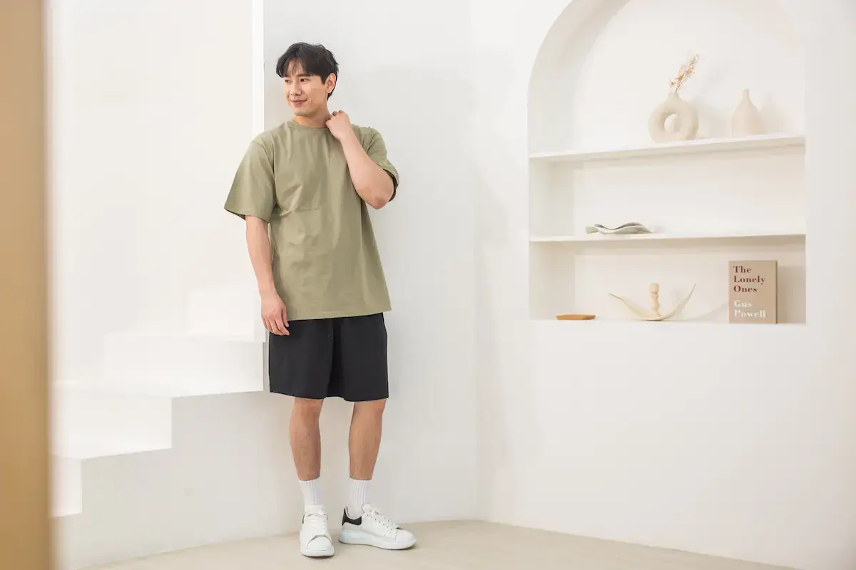 Arrive Guide AG24000 苔蘚綠重磅 T 恤模特穿搭展示，搭配黑短褲呈現清爽的工裝風與大地色系層次感