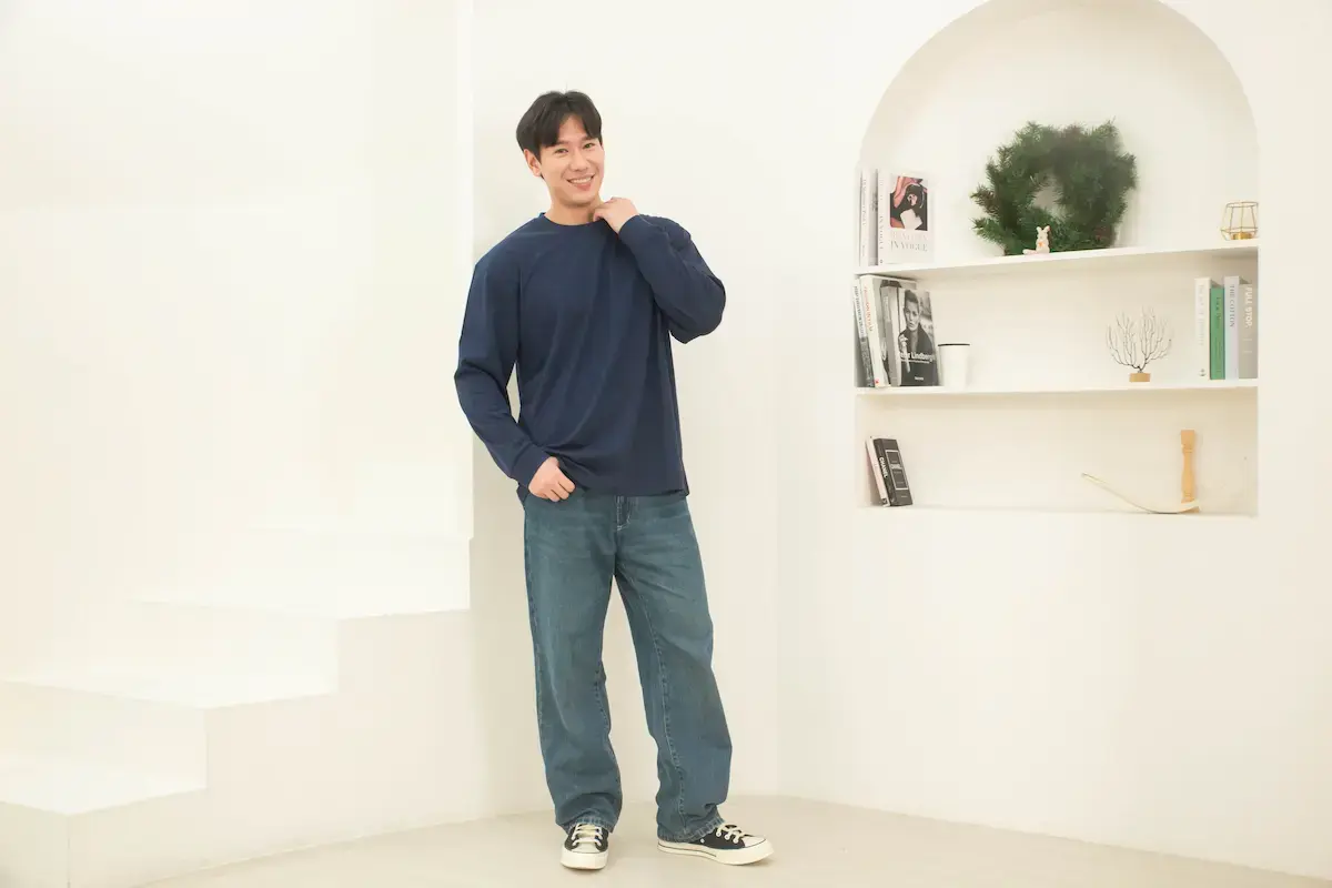 男模特兒穿著 Arrive Guide AG-L210 藏青色重磅長袖 T 恤，展示 210 克精梳棉材質的挺拔修身效果與亞洲版型。