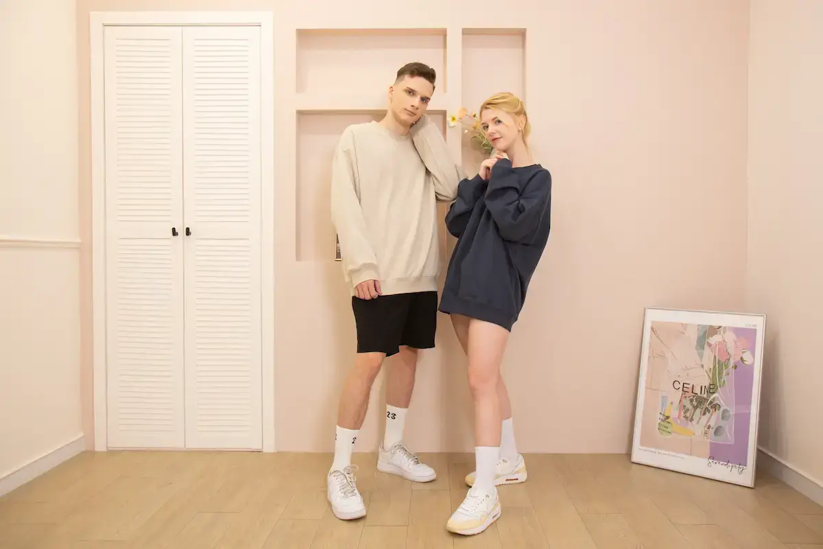 Arrive Guide AG1000 重磅寬版落肩大學T情侶實穿照，男模穿燕麥色，女模穿藏青色 Oversize 下衣失蹤風格