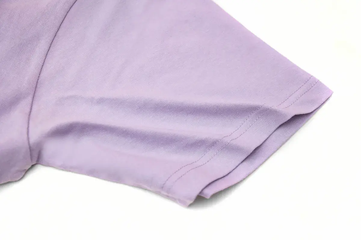 ARRIVE GUIDE AG18000頂級精梳棉T恤 AG18000 薰衣草色 T 恤的袖口細節特寫,展示緊密均勻的雙針縫線與腋下俐落的立體剪裁,布料呈現平整無暇的高質感。